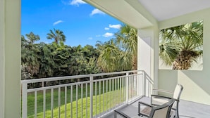A balcony with a view of a well-maintained lawn and palm trees. - 1BR Double Suite w/ ADA Features | Dining & Spa (Miami)