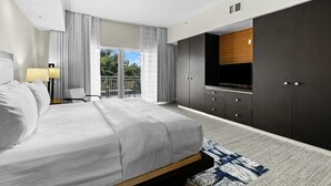 A modern hotel bedroom with a large bed, a TV, and a wardrobe.