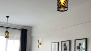Ett modernt sovrum med en säng, en soffa och en hängande lampa.