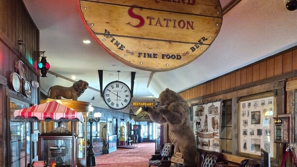 A vintage-themed interior with a wooden sign reading "The Overland Station Fine Food Beer," a vintage telephone, a clock, and a lion statue. - The Tonopah Station  (Tonopah)