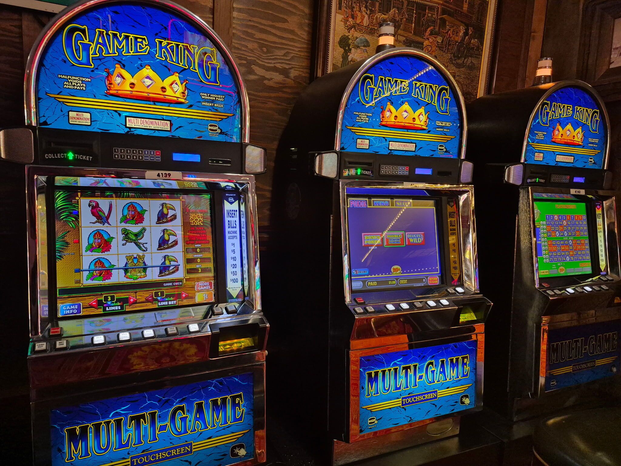 Tres máquinas de arcade con la etiqueta "Game King", presentando los juegos "Multi-Domination" y "Multi-Game".