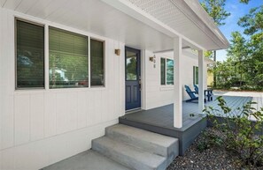 A white house with a porch, steps, and a blue door. - Marvelous 3-bedroom house with AC in charming Palm Harbor/ Ozona (Palm Harbor)