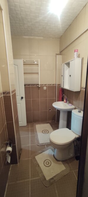 A small bathroom with a toilet, sink, and a cabinet above the sink.