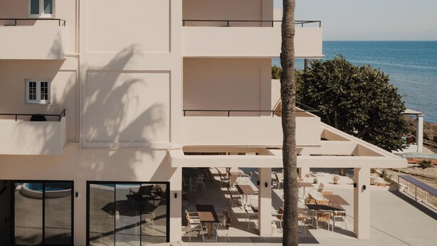 A multi-story hotel with balconies, a pool area, and a view of the sea. - Cavo Notos Beach Hotel (Lefkimmi)