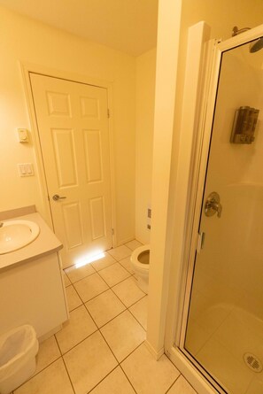 Une salle de bain avec des toilettes, un lavabo et une douche.