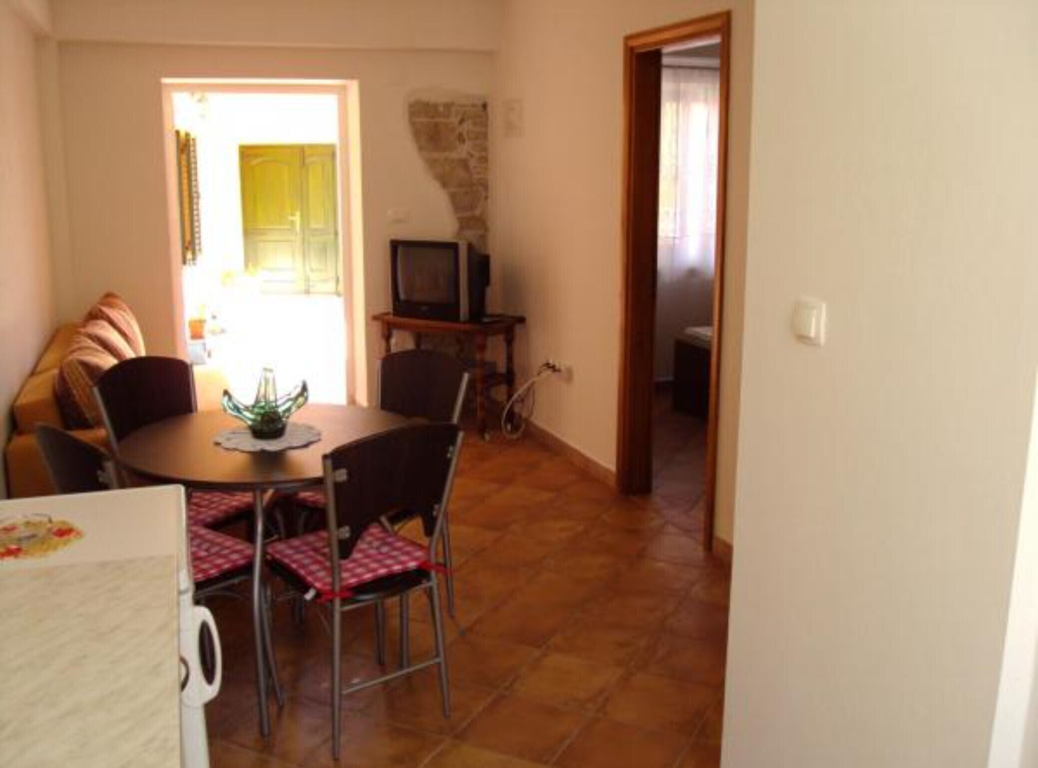 A dining area with a table, chairs, and a television.