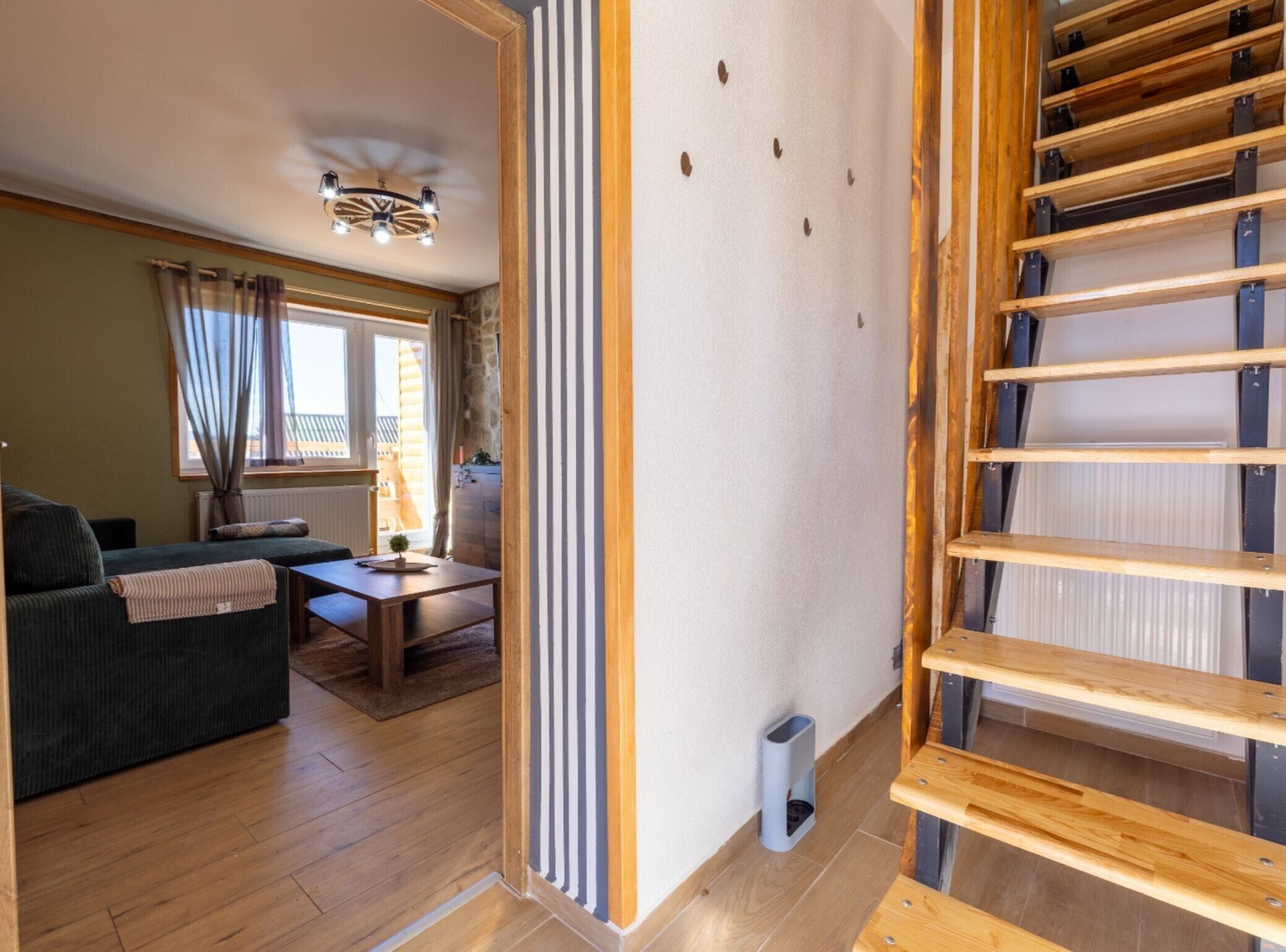 Een gezellige woonkamer met een bank, een klein tafeltje en een raam met gordijnen.