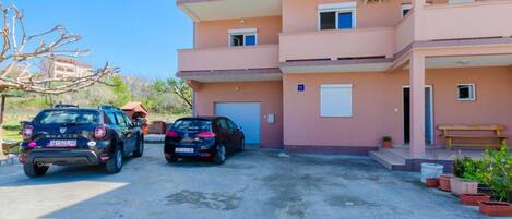 Un edificio residencial de varios pisos con zona de estacionamiento.