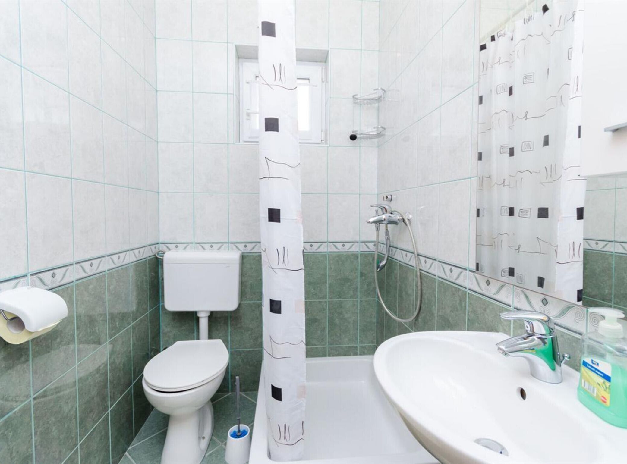 A bathroom with a toilet, a sink, and a shower.