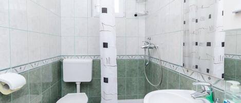 A bathroom with a toilet, a sink, and a shower.
