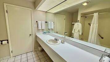 Un baño moderno con un espejo grande, un lavabo blanco y una zona de ducha.