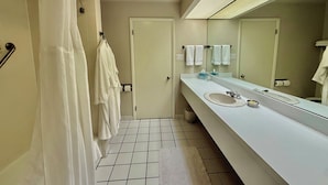 Un bagno moderno con lavandino bianco, specchio e pavimento piastrellato.