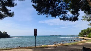 A coastal road with a no parking sign, a clear view of the sea, and a trash bin. - Apartments Ivo Rovinj - Two bedroom apartment (Enzo) (Rovinj)