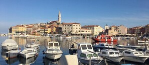 A marina with boats docked, a prominent clock tower, and historic buildings in the background. - Villa Tena - One Bedroom Apartment Anthea (Rovinj)