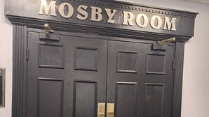A double door with the inscription 'MOSBY ROOM' above it.