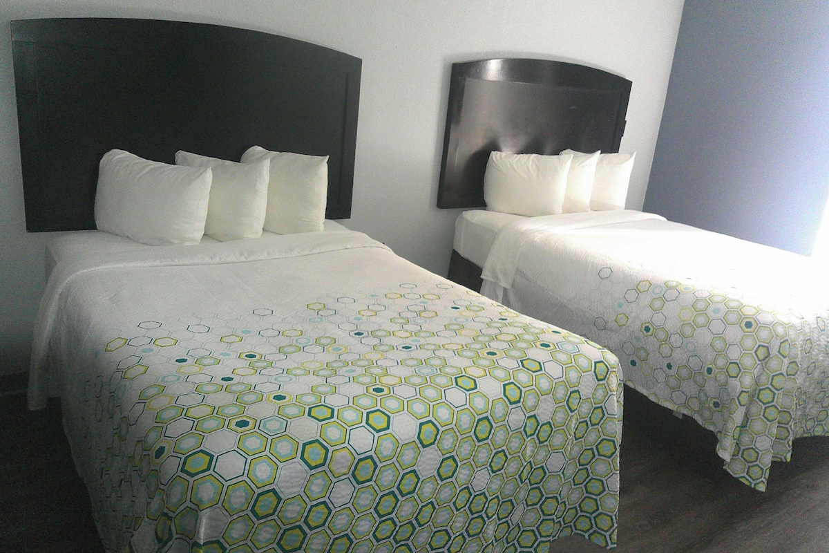 Two single beds with headboards, white bedding, and a geometric pattern on the bedspread.