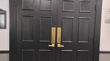 Una puerta doble negra con un letrero que dice 'ASHBY ROOM'.