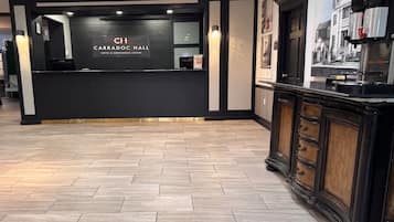 Una hall d'albergo dal design moderno, con una reception e una macchina per il caffè.