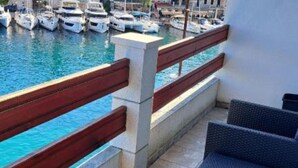 Un balcon donnant sur une marina où sont amarrés plusieurs bateaux.