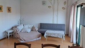 Un salon comprenant un canapé, une petite table et une table à manger avec des chaises.