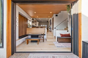 Ein modernes Interieur mit einer Holzbank, einer Treppe und Blick in die Küche.