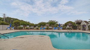 Piscina com cadeiras de descanso azuis e placa indicando profundidade de 1,4 metros.