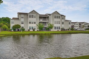 A multi-story apartment building with a central courtyard and a small pond. - 2 Mi to Shore: Surfside Beach Condo w/ Pool Access (Surfside Beach)
