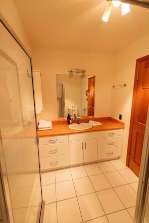 A bathroom with a shower, a sink, and a mirror. - Spacious Eagle’s Nest Cabin – Lakeside Escape at Our Gathering Place (Lac la Hache)