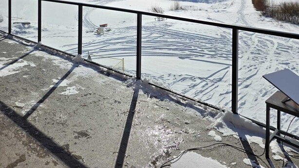 A wooden ceiling, a metal railing, and a snowy landscape with trees and a clear sky. - 4 Bdrm Lodge Suite w Hot Tub, beautiful Lake views! Pet Friendly (Naramata)