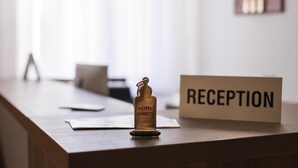 Una mesa de recepción con un cartel que dice "RECEPTION" y un llavero del Hotel Amico.
