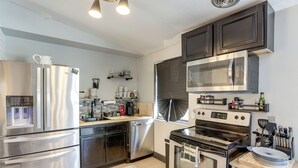 A modern kitchen with stainless steel appliances, wooden cabinets, and a built-in oven. - 6 Mi to Dtwn Toledo! Family-Friendly Haven w/ Deck (Toledo)