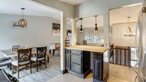A modern kitchen with a central island, dark cabinetry, and pendant lighting. - 6 Mi to Dtwn Toledo! Family-Friendly Haven w/ Deck (Toledo)