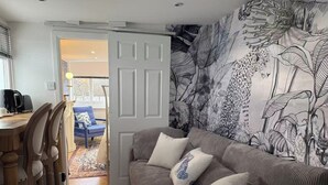 A living room with a grey sofa, a coffee table, and a patterned wall. - Lakeside Haven in London (London)