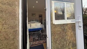 A room with a bed, a window, and a door leading outside. - Lakeside Haven in London (London)