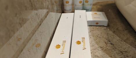 Three white boxes with a logo and text on a marble surface, likely containing hotel amenities.