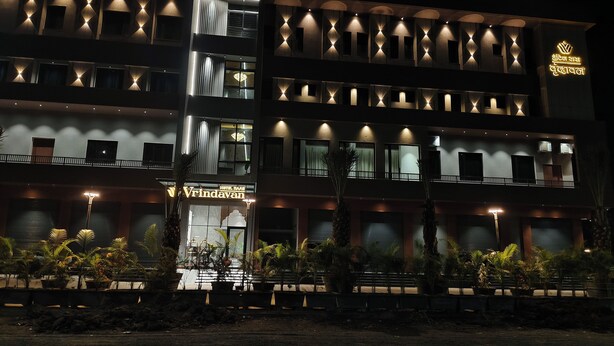 Un hôtel à plusieurs étages, doté d’une façade moderne, de balcons et d’une entrée bien éclairée.