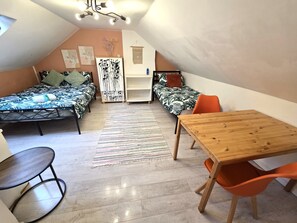 Una stanza piccola e accogliente con due letti, un tavolo di legno e una sedia.