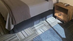 A bedroom with a bed, a nightstand, a lamp, and a ceiling fan. - The Melrose Motel  (Sandusky)