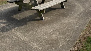 A picnic table with four benches on a concrete surface in a park. - The Melrose Motel  (Sandusky)