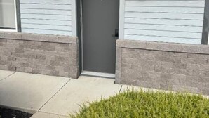 A modern building with a grey door marked with the number 3, flanked by two lantern-style lights. - The Melrose Motel  (Sandusky)
