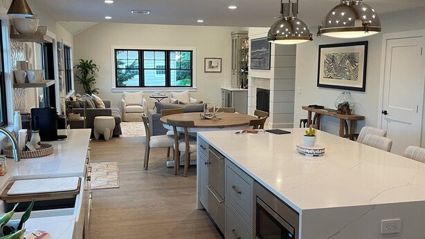 A spacious kitchen with a large island, modern pendant lights, and a view of the outdoors through a window. - North Fork Waterfront Oasis in Mattituck (Mattituck)