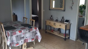 A bedroom with a bed, a desk, a chair, a dresser, and a mirror.