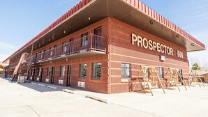 Un edificio con fachada roja y el nombre 'PROSPECTOR INN' en el lateral.