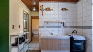 Une salle de bain avec un plafond en bois, un lavabo, un miroir, une étagère avec des articles de toilette et un porte-serviettes.