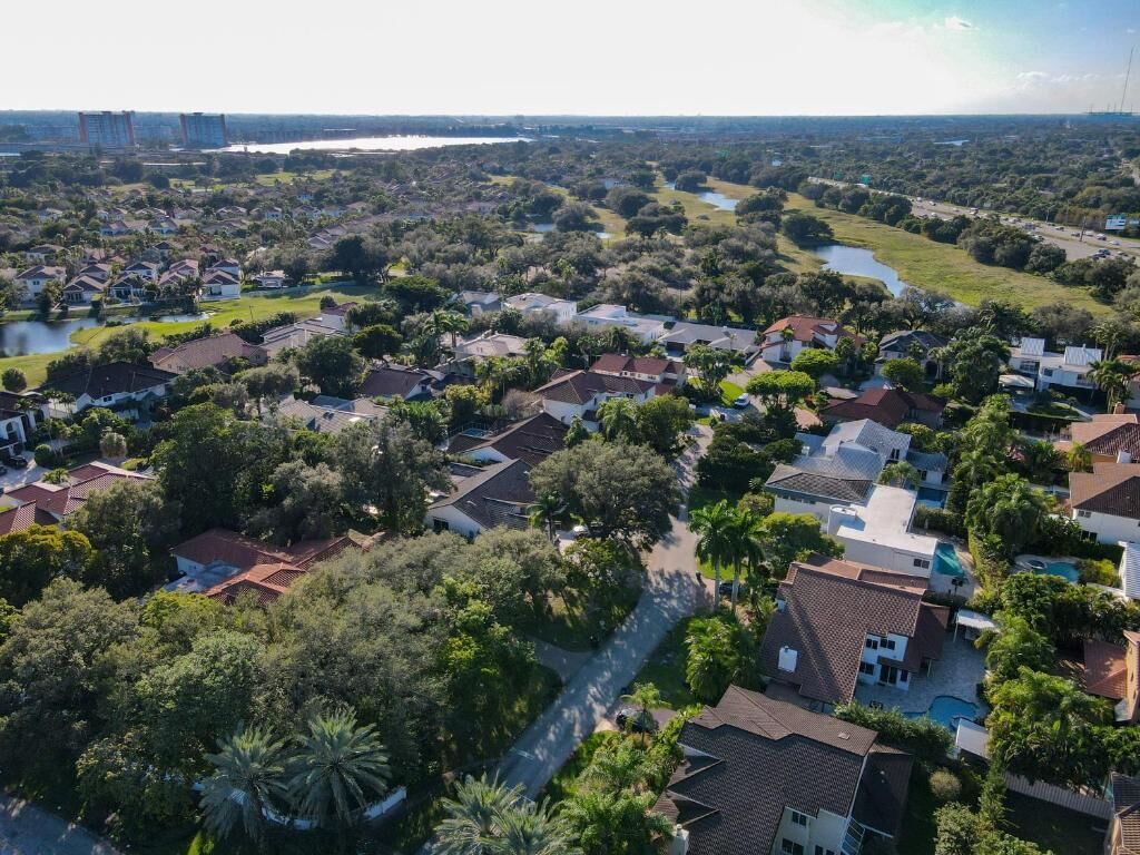 An aerial view of a residential area with houses, trees, and a river.