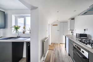 Une cuisine moderne équipée d’un lave-vaisselle, d’un four à micro-ondes et d’une cuisinière.