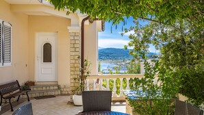 Uma varanda com vista para o mar, uma porta e mobiliário de exterior.