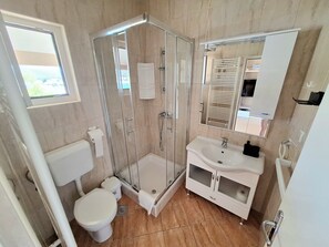 Regadera, secadora de cabello, toallas, papel de baño 