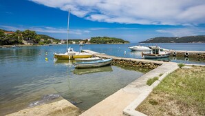 Un puerto deportivo con barcos amarrados, agua tranquila y cielo despejado.