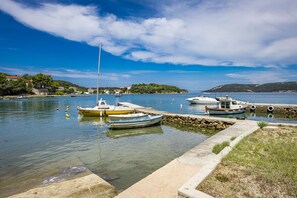 A marina with boats docked, calm water, and a clear sky.